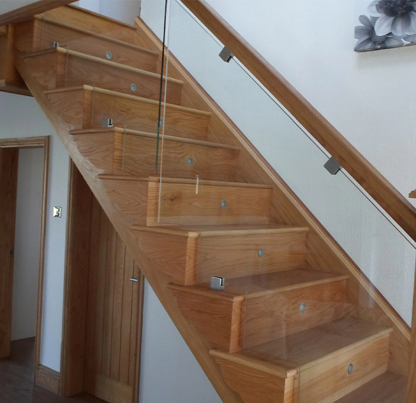 Glass balustrades with wooden handrail around a staircase