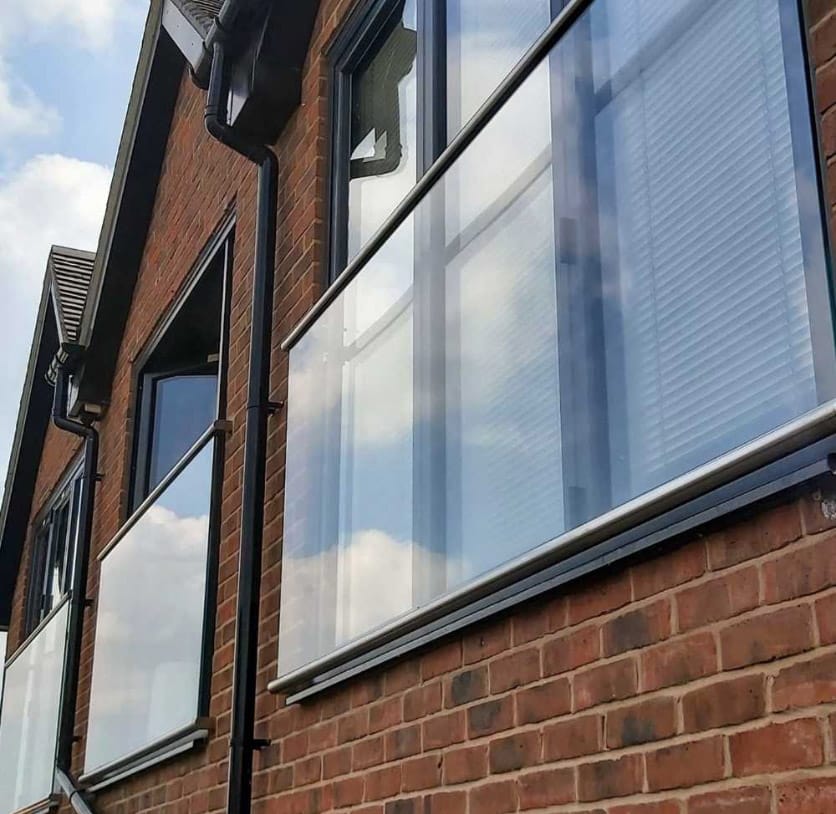 Juliet balcony with stainless steel handrail across several windows