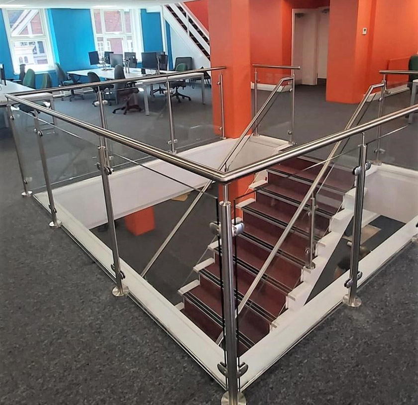 Partial glass balustrade with stainless steel handrail for an office staircase