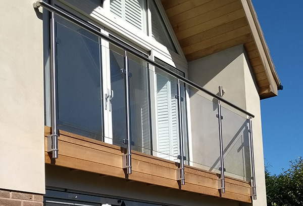 Glass balustrade with stainless steel posts and handrail along upper floor balcony