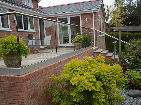 Glass balustrade with stainless steel handrail on a garden balcony