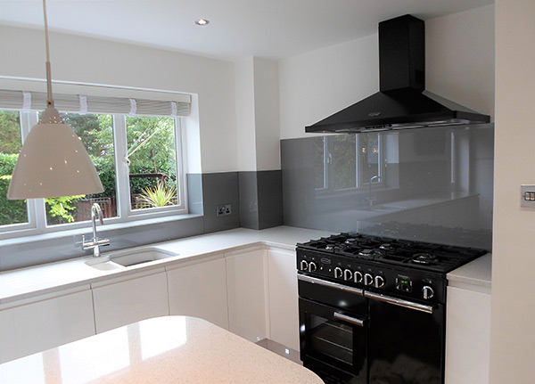 Grey coloured glass splashback above kitchen countertop