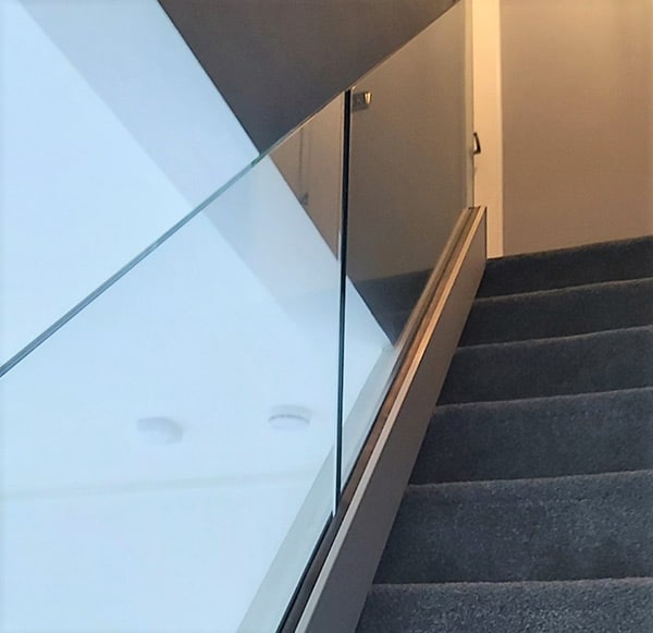 Glass balustrade for carpeted staircase