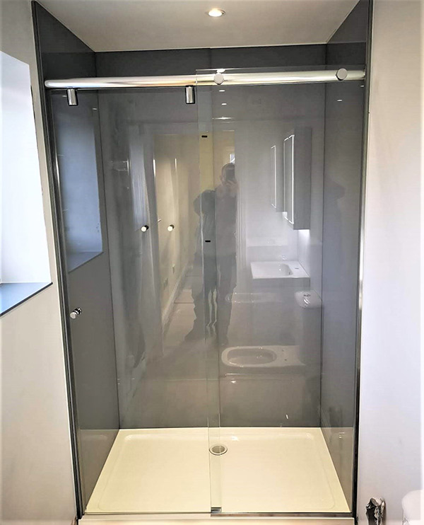 Glass sliding shower screen with stainless steel rail