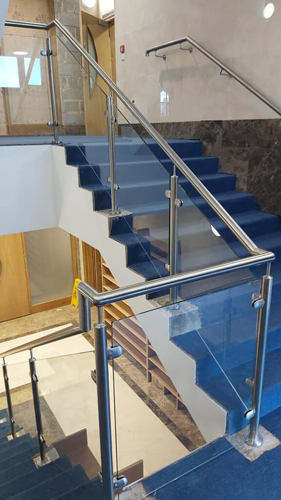 Partial glass balustrade with stainless steel handrail for an office staircase