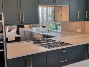 Silver mirror toughened splashback with socket cut outs across the length of a countertop